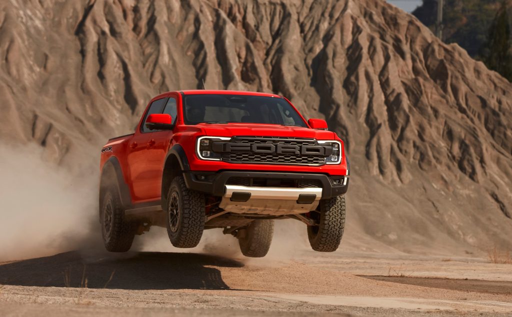 ford ranger raptor jumping an obstacle on a desert course