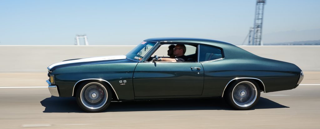 1972 chevy chevelle with lowered aldan american suspension driving across a bridge on highway