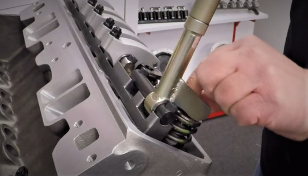 Man installing valve springs and keepers into a cylinder head