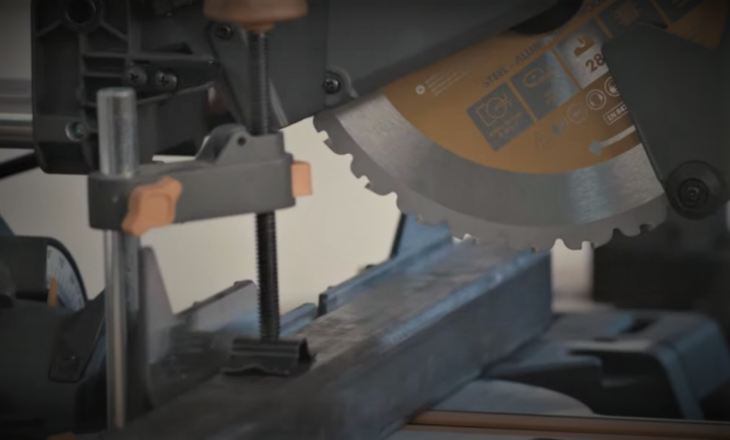 miter saw cutting a piece of steel tubing