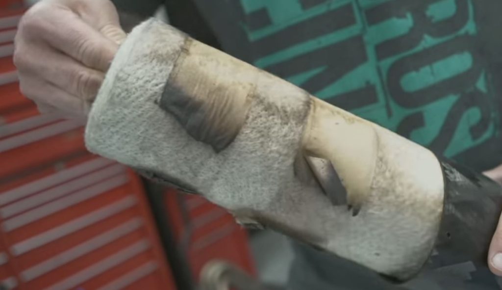 man removing packing baffle from sport bike motorcycle muffler