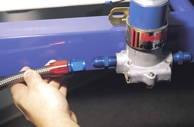man installing hose into an external fuel pump