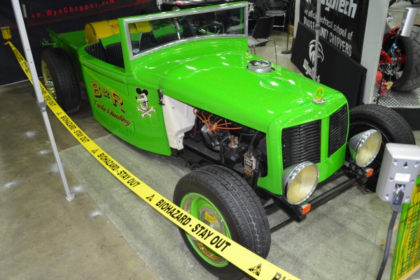 green custom hot rod roadster in a car show