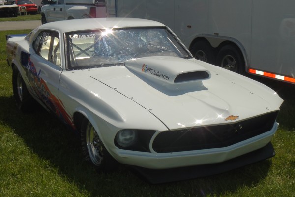 vintage ford mustang drag car near trailer