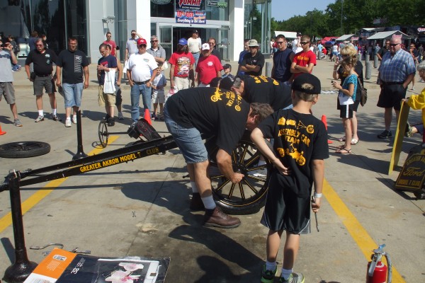 men assembling a ford model t demonstration, front wheels