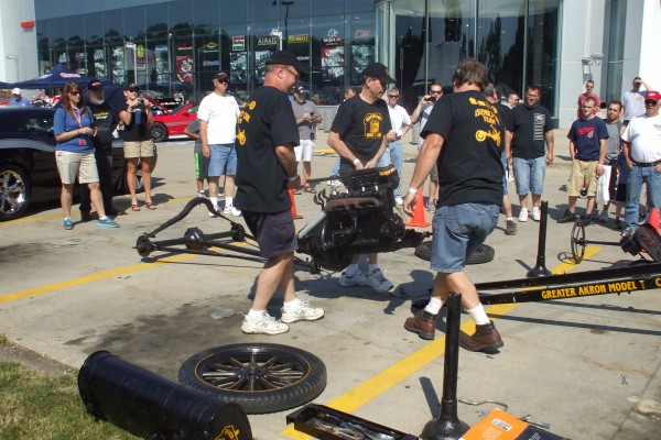 men assembling a ford model t demonstration, fitting engine