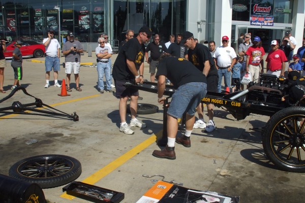 men assembling a ford model t ,jacking frame demo