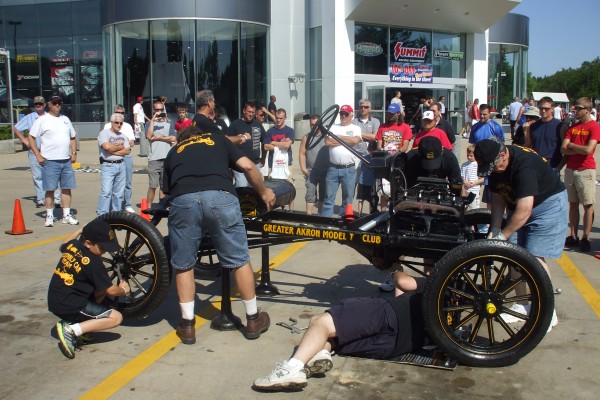 men assembling a ford model t demonstration, with engine