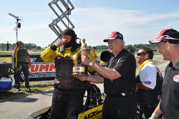 racer getting a nhra wally trophy