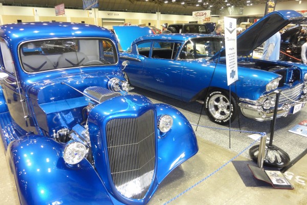 a pair of blue street rods at a car show