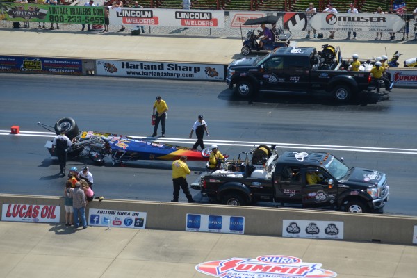 crew removing a flipped dragster from the track