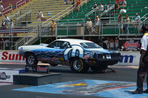 mopar plymouth barracuda doing a wheelstand at drag race start