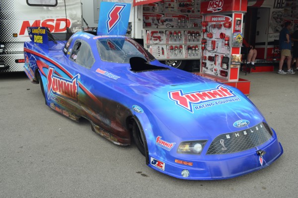 Summit Raving NHRA Funny Car with fire wheel damage