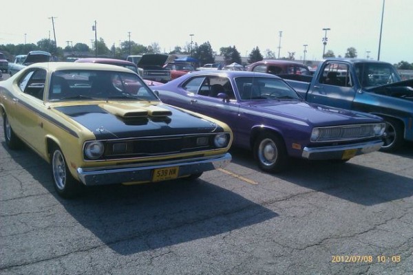 a pair of classic mopar muscle cars at a show