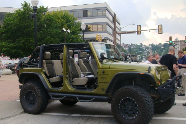 Green Jeep Wrangler Unlimited with doors removed