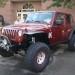 Maroon lifted Jeep Wrangler with off road tires thumbnail
