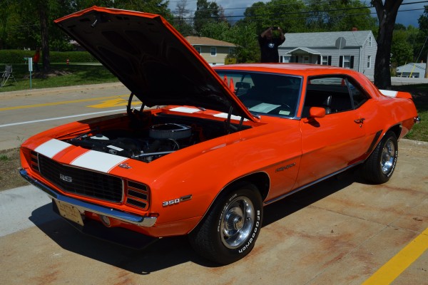 an orange 1969 chevy camaro rs in hugger orange with stripes