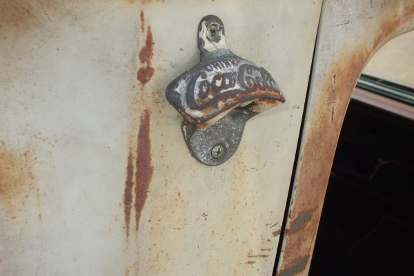 coca cola bottle opener on a vintage truck bed