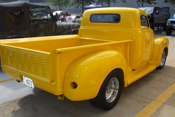 rear view of a yellow hot rod pickup truck