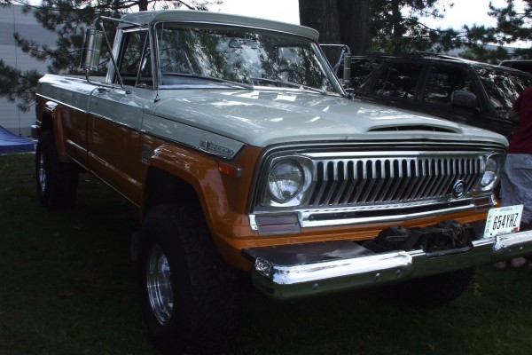 vintage jeep j series pickup truck at a car show