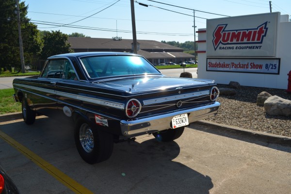 1965 Ford Falcon near summit racing sign