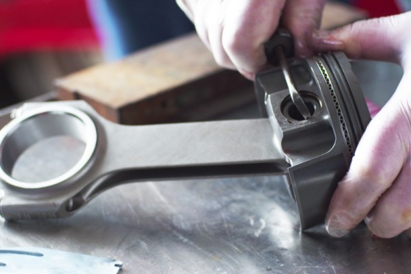 installing wrist pin retainers in a piston head