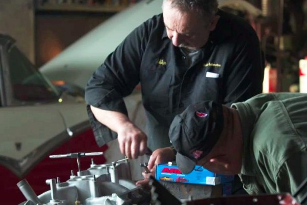 man installing carb studs on an intake manifold