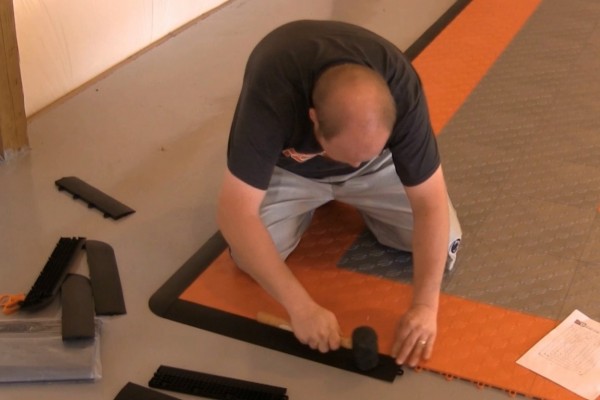 man installing garage floor tiles