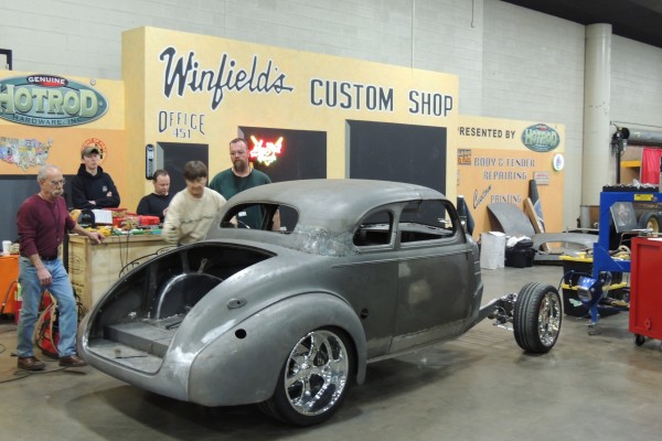 Hot rod being modified during a car show demonstration