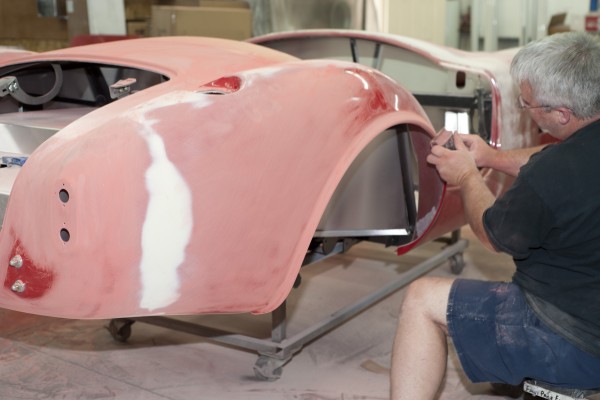 sanding fender edge bodywork on a classic car