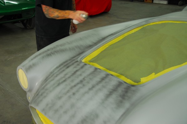 spraying primer on a classic car body