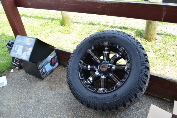 wheel sitting against a wooden fence