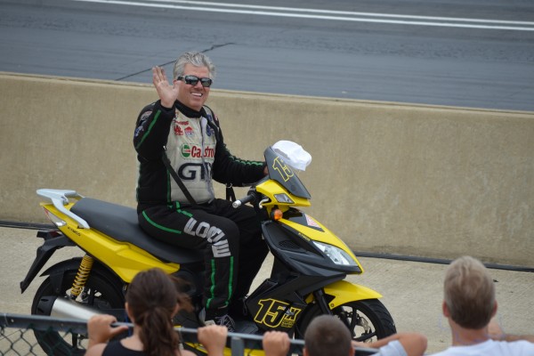 John Force riding around on a pit bike