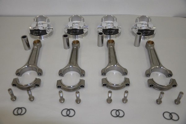 connecting rods and piston heads sitting on a table