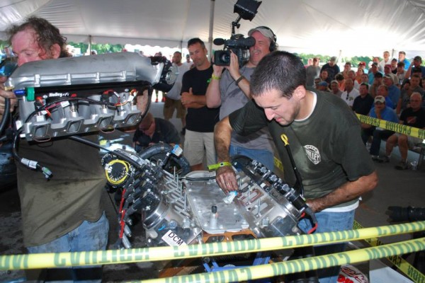 men rebuilding a gm ls engine during a contest