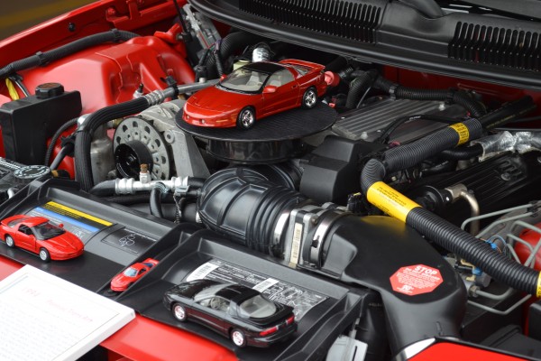 model toy cars displayed under the hood of a fourth gen pontiac firebird