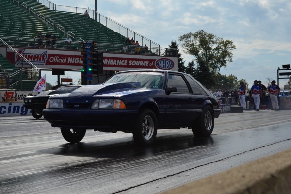 a fox body ford mustang launching at a drag strip