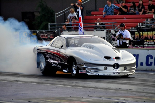a pontiac trans am fourth gen drag car doing a burnout prior to a race