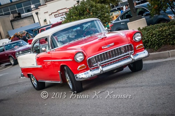1955 chevy bel air hot rod coupe with custom wheels entering a car show