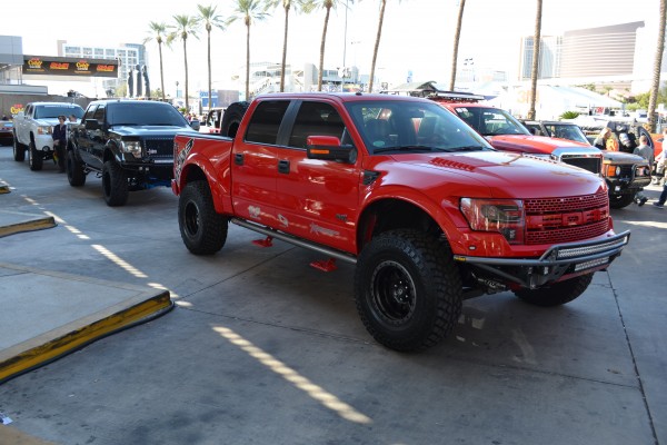 rows of custom late model trucks displayed at SEMA 2013