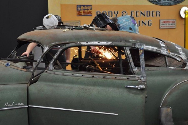 men working on building a hot rod coupe