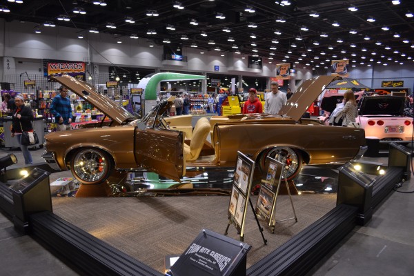 custom gold convertible show car displayed at indoor car show