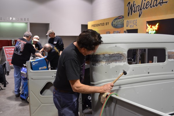 Gene Winfield hammering a truck cab during a hot rod build