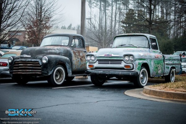a pair of vintage chevy pickup trucks at a classic car show
