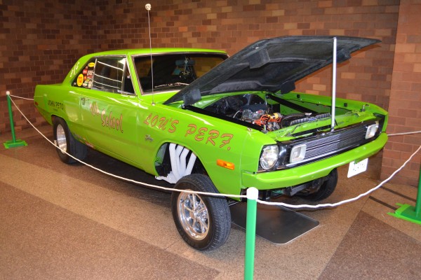 green custom dodge dart straight axle gasser displayed at indoor car show