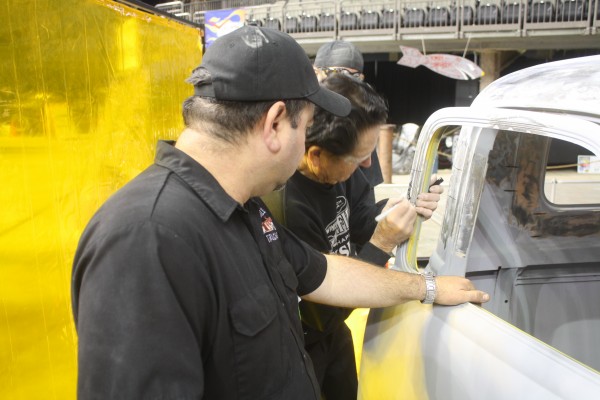 men measuring door window frame prior to chopping it for a hot rod build