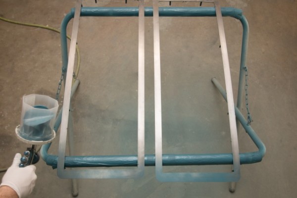 spraying a truck grille with custom primer