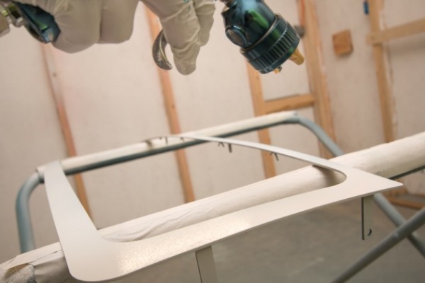 spraying a truck grille with custom paint