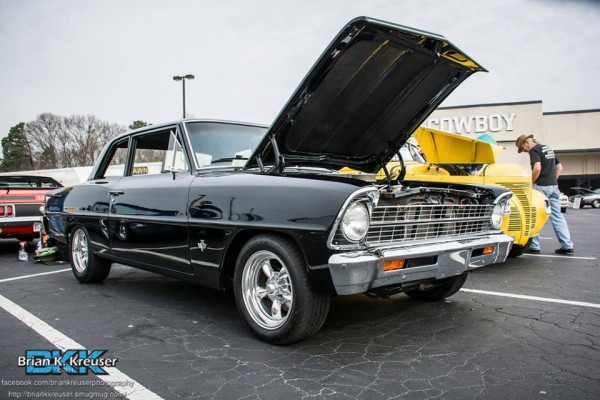 a black chevy 2 nova coupe with custom wheels