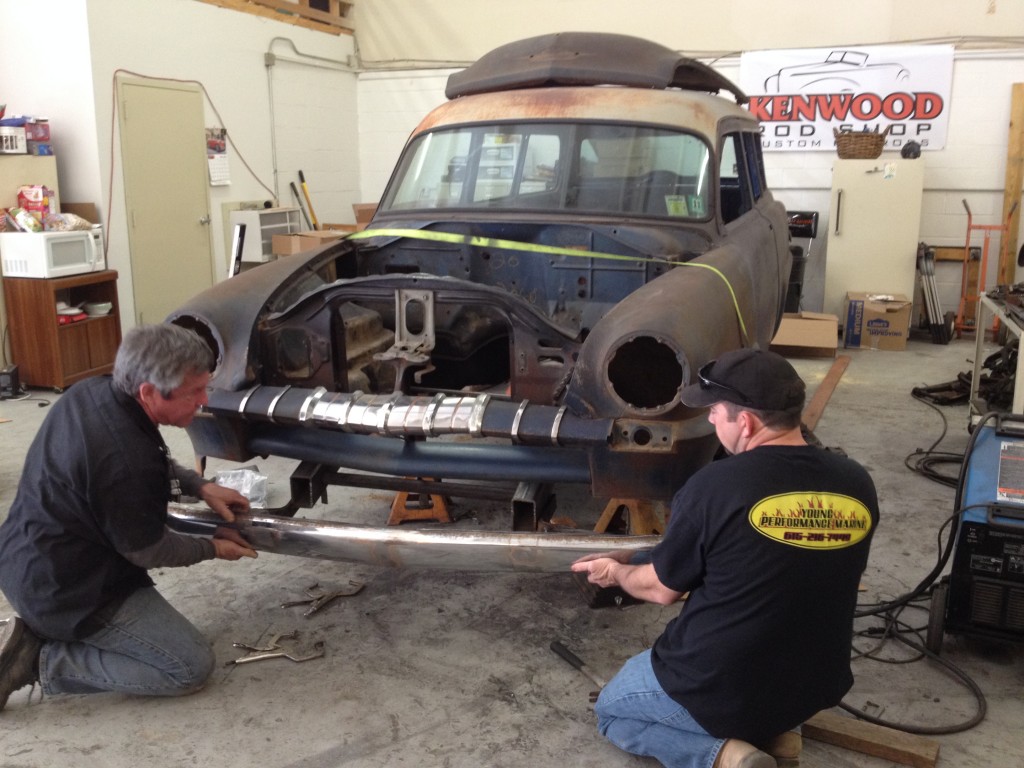 two men fitting a bumper to a custom car build